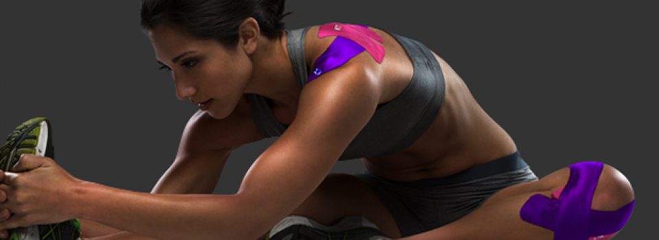 A woman with a purple and pink kinesio tape on her arm.