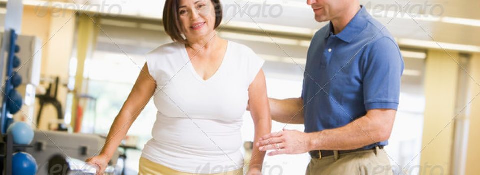 A man and woman in the gym with some exercise equipment.